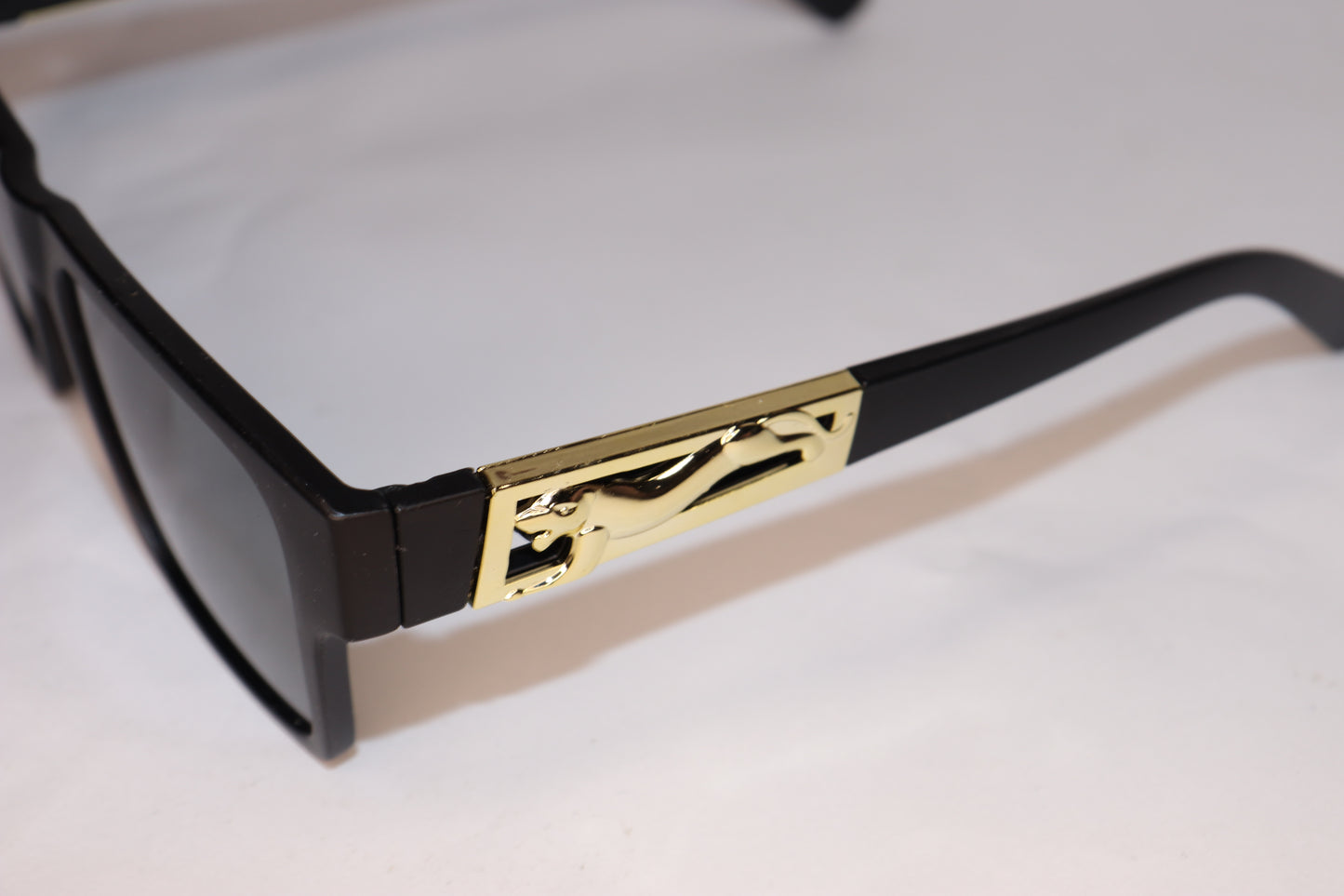 Sunglasses with black frame and gold decorative element